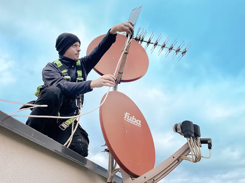 Technicien installant une antenne TNT sur une toiture à Strasbourg.