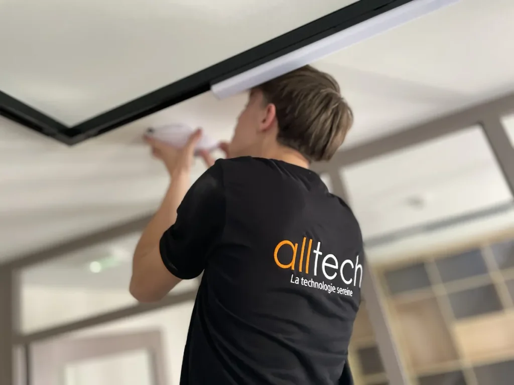 Technicien Alltech posant une borne Wi-Fi au plafond